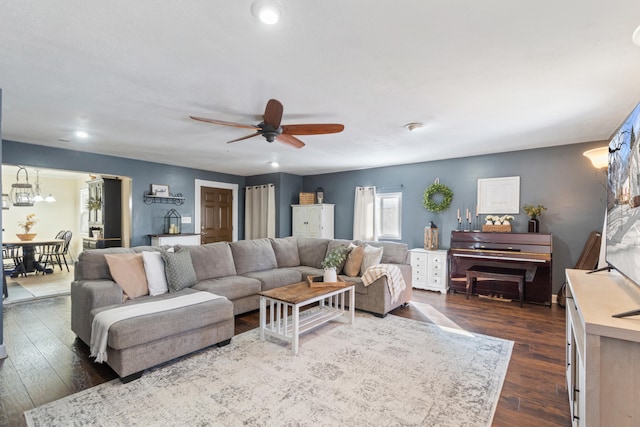 living room featuring ceiling fan and dark wood-type flooring