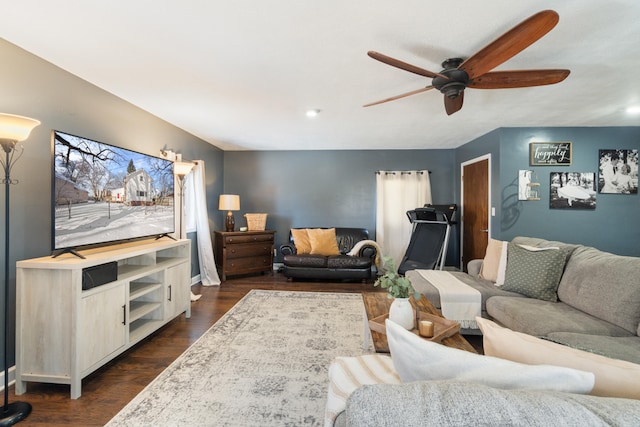 living room featuring dark wood-type flooring and a ceiling fan