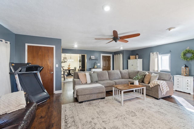 living area featuring ceiling fan and dark wood-type flooring