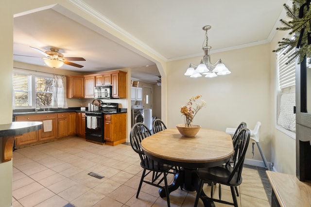 dining area with ceiling fan with notable chandelier, independent washer and dryer, light tile patterned flooring, and crown molding