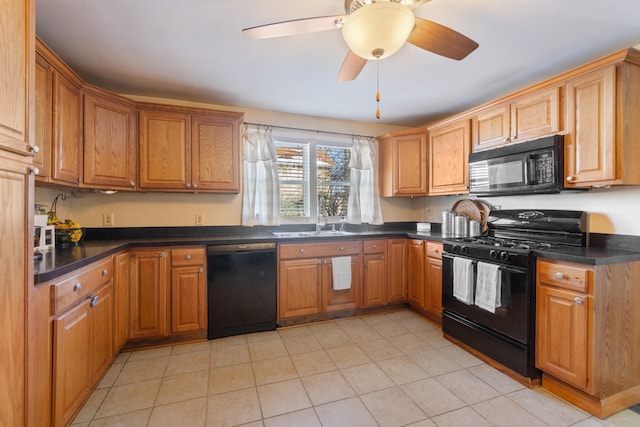 kitchen with brown cabinetry, dark countertops, a sink, and black appliances