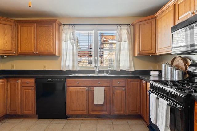 kitchen featuring dark countertops, black appliances, brown cabinets, and a sink