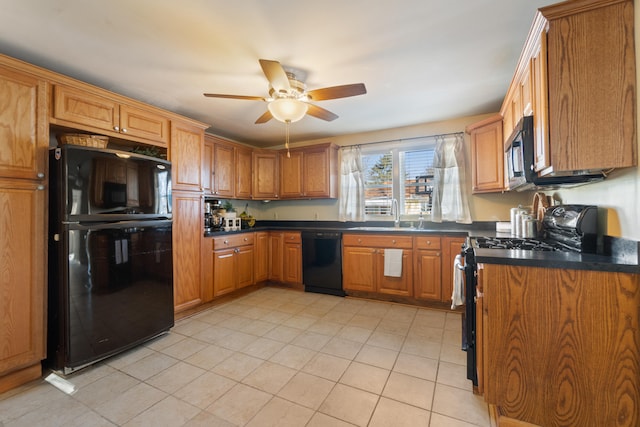 kitchen with dark countertops, a sink, and black appliances