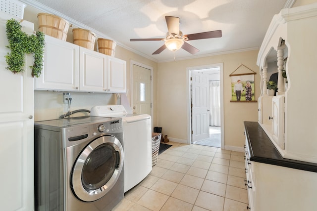 washroom featuring cabinet space, light tile patterned floors, baseboards, crown molding, and separate washer and dryer