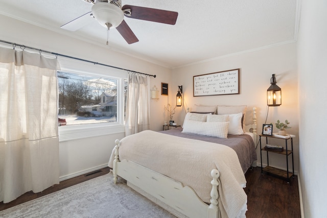 bedroom featuring a ceiling fan, dark wood-style flooring, crown molding, and baseboards