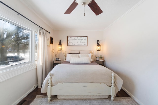 bedroom with ornamental molding, a ceiling fan, baseboards, and wood finished floors