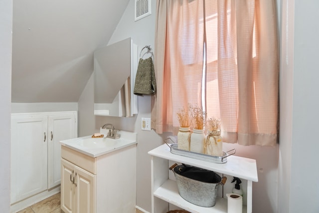 bathroom with lofted ceiling, visible vents, and vanity