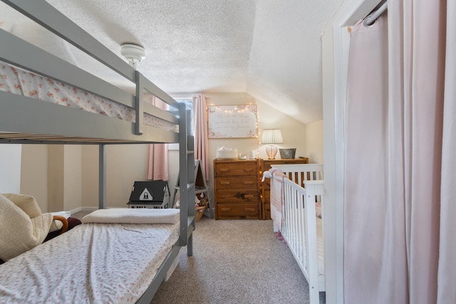 bedroom featuring lofted ceiling, a textured ceiling, and light colored carpet