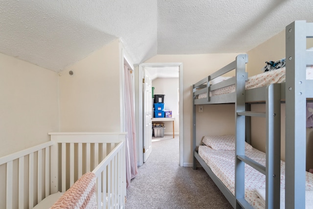 carpeted bedroom featuring lofted ceiling and a textured ceiling