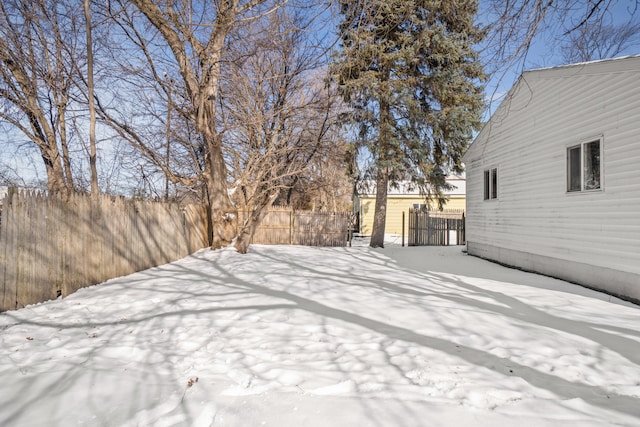 yard covered in snow featuring fence