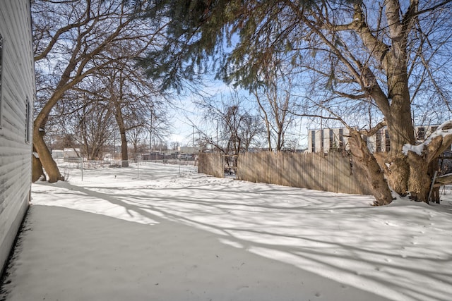 yard covered in snow featuring fence