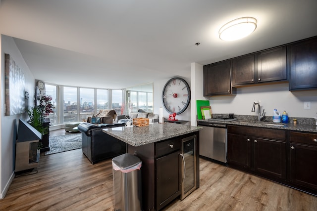 kitchen featuring a sink, open floor plan, dark brown cabinets, a center island, and dishwasher