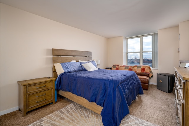 bedroom with light carpet and baseboards