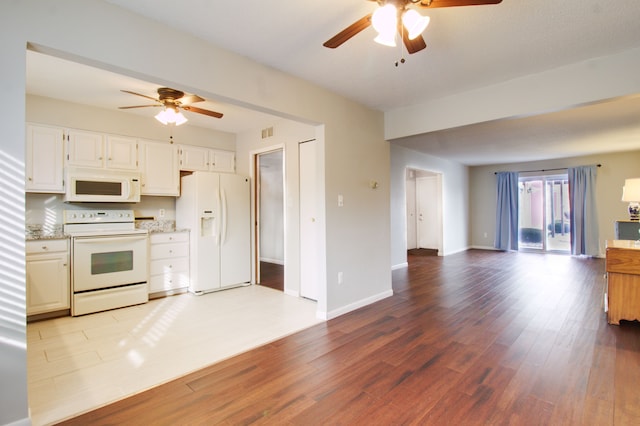 kitchen with open floor plan, white appliances, wood finished floors, and baseboards