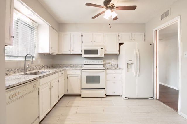 kitchen featuring visible vents, ceiling fan, a sink, light stone countertops, and white appliances