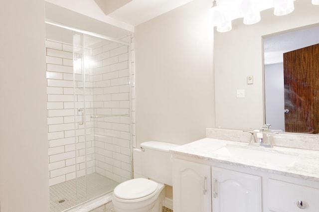 bathroom featuring a shower stall, toilet, and vanity