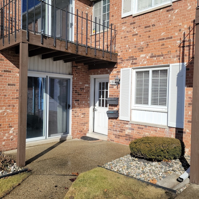 entrance to property with a balcony and brick siding