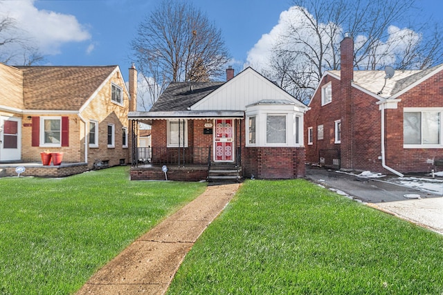 bungalow with brick siding, a porch, and a front yard