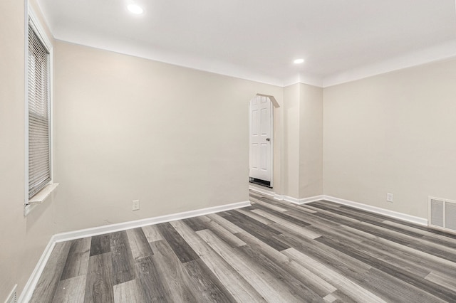 empty room with recessed lighting, wood finished floors, visible vents, and baseboards