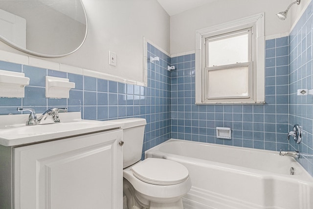 bathroom with toilet, vanity, tile walls, shower / bathing tub combination, and wainscoting