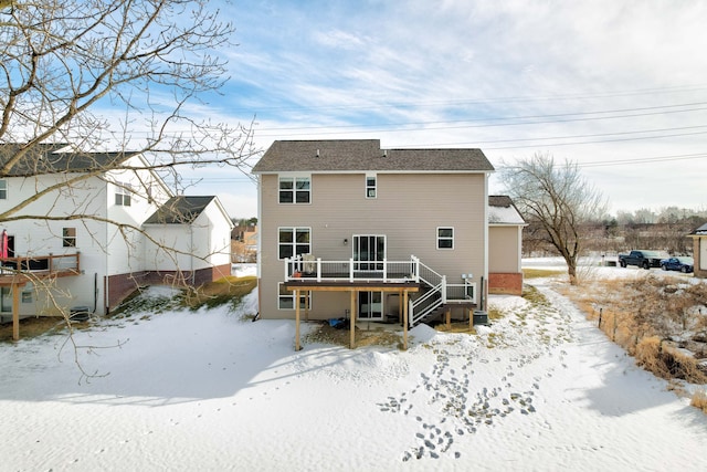 snow covered property featuring a wooden deck