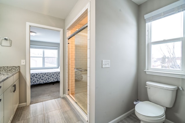 ensuite bathroom with a stall shower, connected bathroom, vanity, and toilet