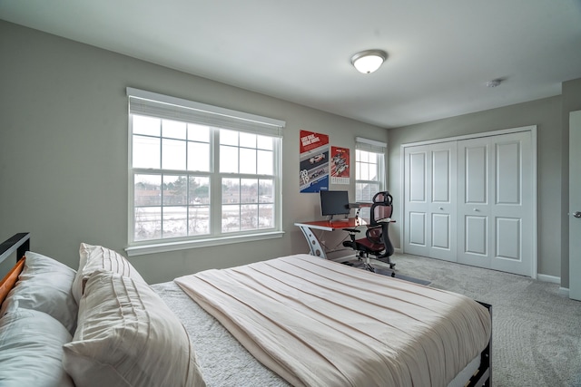 carpeted bedroom featuring a closet and baseboards