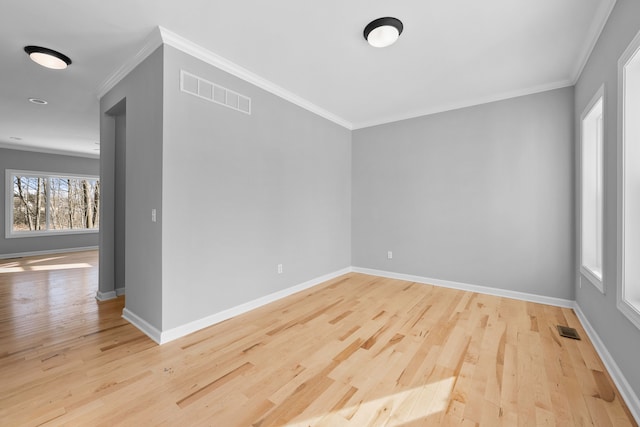 unfurnished room with ornamental molding, visible vents, and light wood-style floors