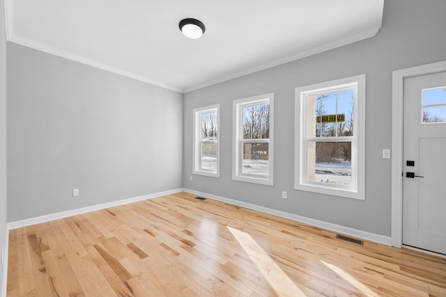 foyer featuring ornamental molding, visible vents, and baseboards