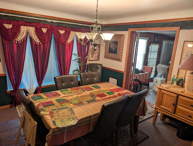 carpeted dining space with a chandelier