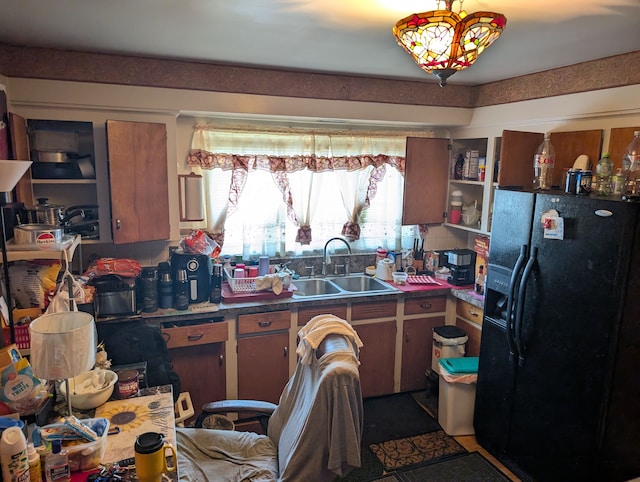 kitchen featuring decorative backsplash, dark countertops, brown cabinets, black refrigerator with ice dispenser, and a sink