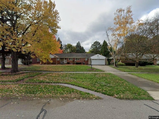 single story home featuring a garage, concrete driveway, and a front lawn