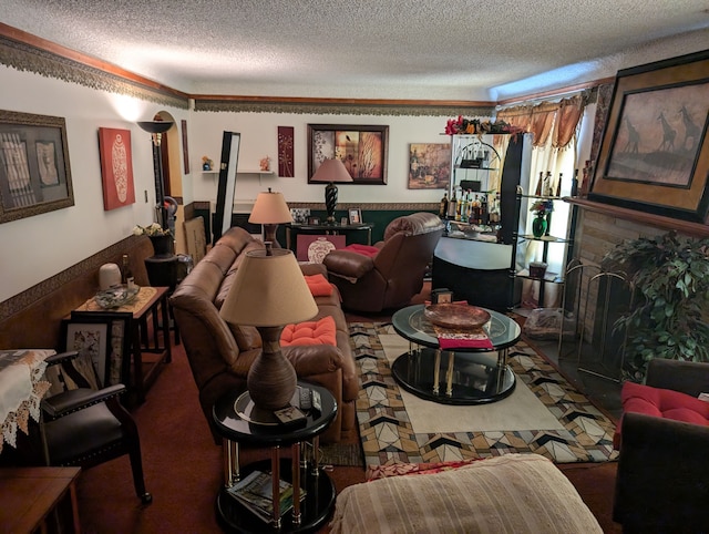 living room featuring ornamental molding, a wainscoted wall, a fireplace, and a textured ceiling