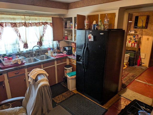 kitchen featuring a sink and black fridge with ice dispenser