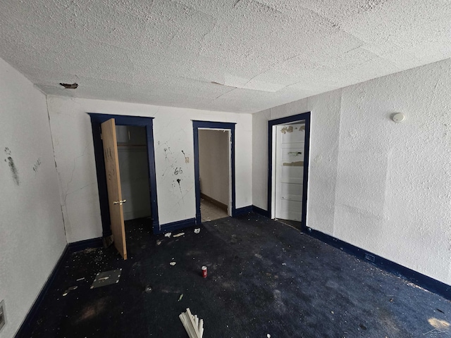 unfurnished bedroom featuring visible vents, a textured ceiling, and baseboards