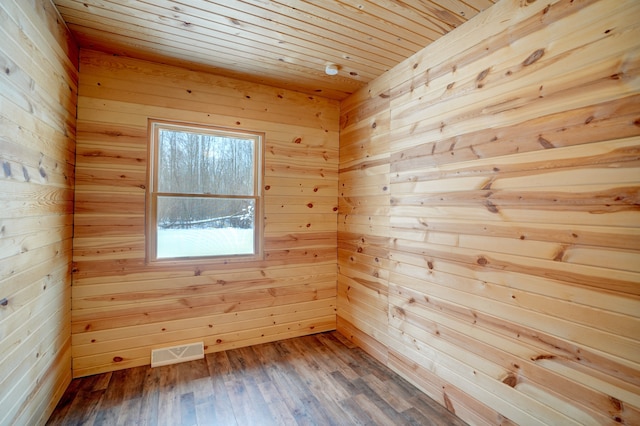 empty room with wood ceiling, visible vents, a sauna, and wood finished floors