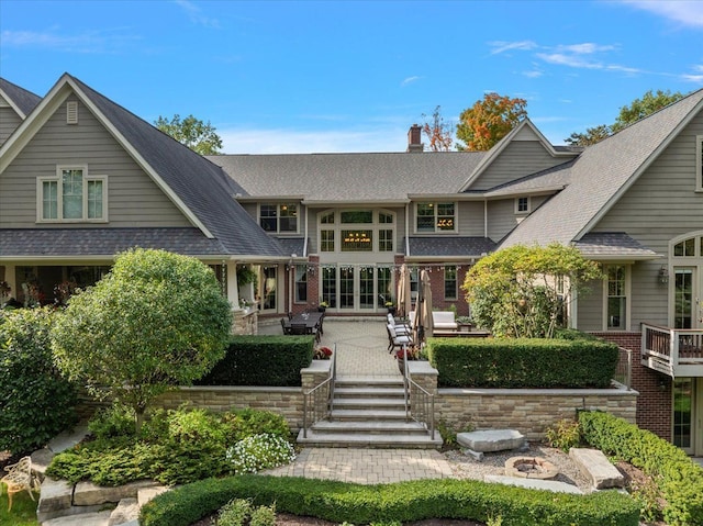 back of property featuring a patio, brick siding, and a chimney