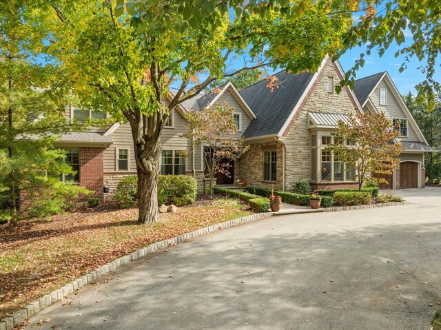 view of front of home featuring stone siding and driveway