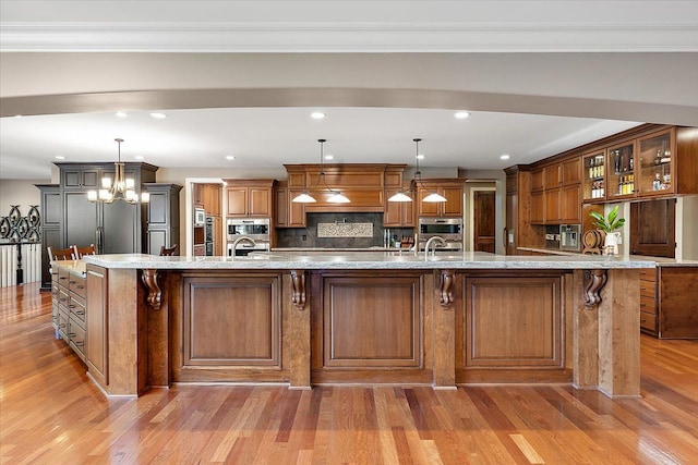 kitchen featuring brown cabinetry, a spacious island, glass insert cabinets, and decorative light fixtures