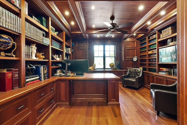 office featuring built in shelves, crown molding, wood walls, ceiling fan, and light wood-type flooring