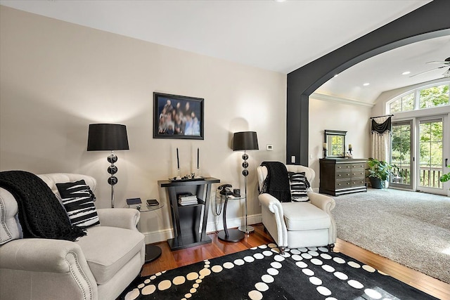 interior space featuring arched walkways, vaulted ceiling, dark wood finished floors, and baseboards