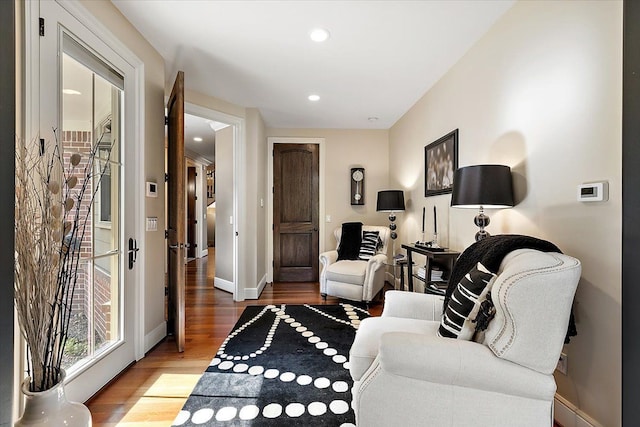 living area featuring baseboards, wood finished floors, and recessed lighting