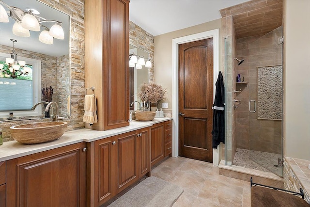 bathroom featuring a chandelier, a shower stall, and vanity