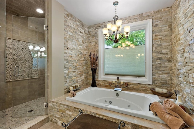 bathroom with a whirlpool tub, a shower stall, and a notable chandelier