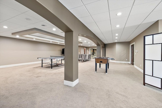 playroom with arched walkways, recessed lighting, light colored carpet, a drop ceiling, and baseboards