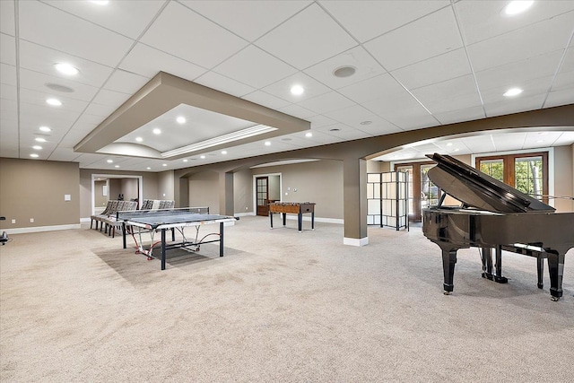 game room with baseboards, french doors, arched walkways, and light colored carpet