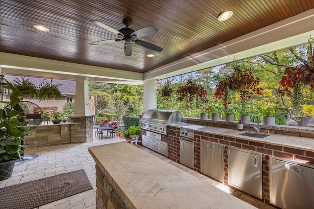 view of patio / terrace with exterior kitchen, a sink, area for grilling, and a ceiling fan