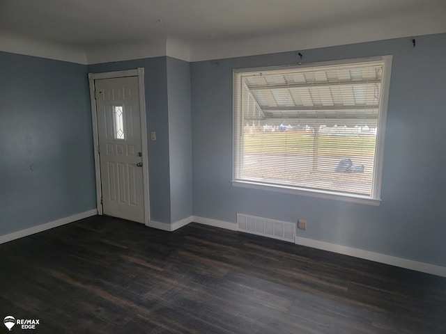 foyer with dark wood-style floors, baseboards, and visible vents