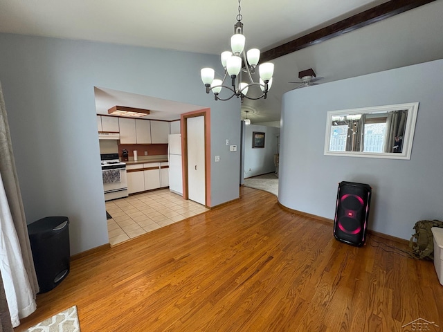 kitchen featuring decorative light fixtures, light wood-style floors, white cabinets, white appliances, and under cabinet range hood