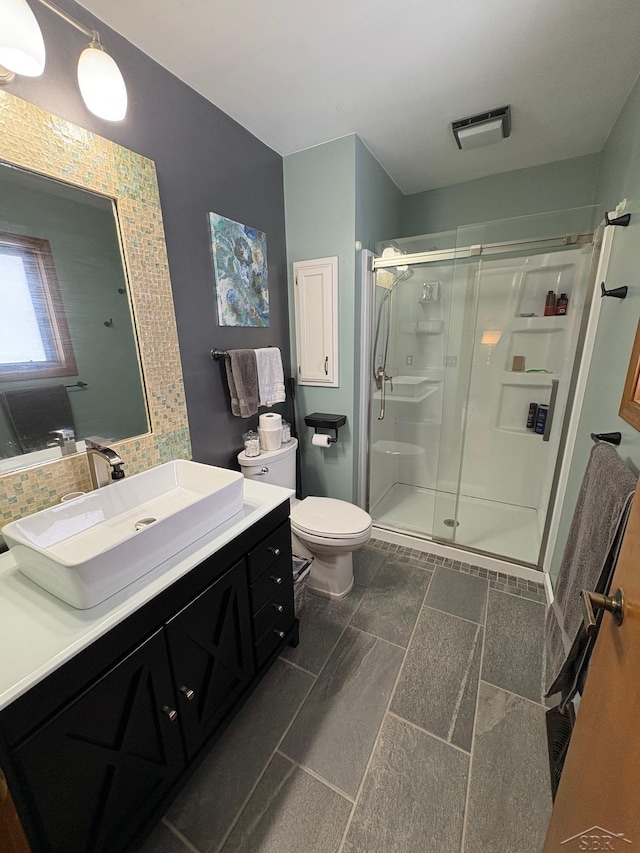 bathroom featuring toilet, visible vents, a stall shower, and vanity